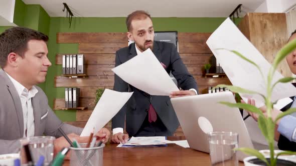 Businessman in Suit with Management Team in the Conference Room