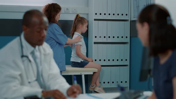 Medical Assistant Using Stethoscope on Small Child to Do Consultation