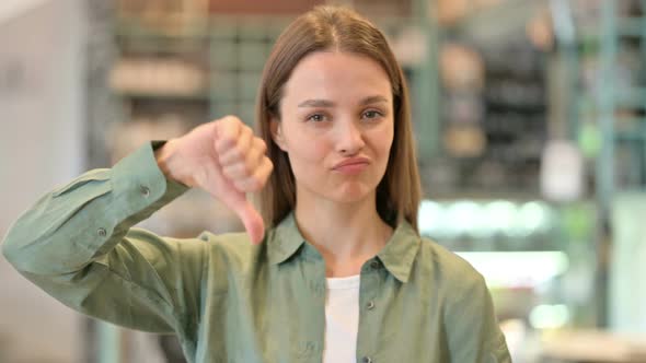 Portrait of Disappointed Woman Doing Thumbs Down 