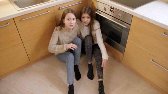 Two Girls Hiding From Aggression or Anger of Parent