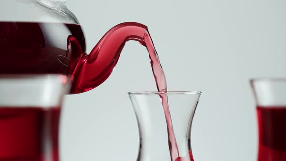 Pouring Red Fruit Tea on White Background