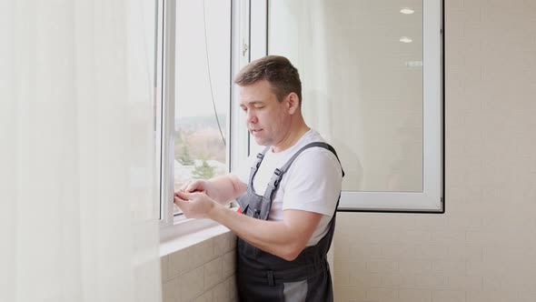 a Repairman Repairs Adjusts or Installs Metalplastic Windows in the Apartment