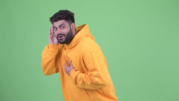 Happy Young Overweight Bearded Indian Man Listening and Getting Good News