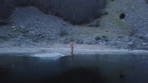 Young man walking on the ice. Top view of  frozen Lake  in Montenegro.