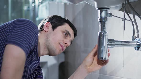 Man Repairing a Leaking Pipe