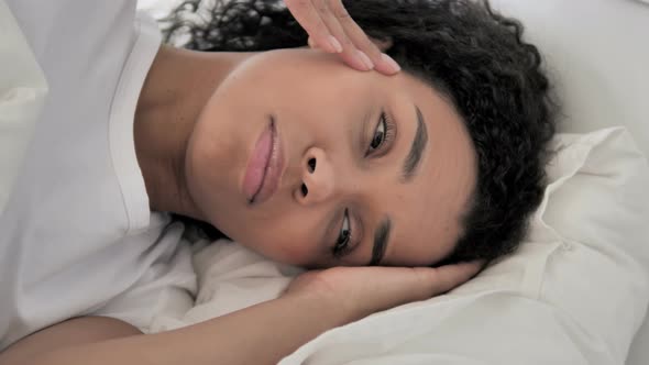 African Woman with Headache Lying in Bed