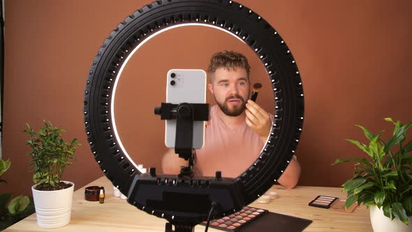 Young Man Filming His Video Blog Episode About New Cosmetic Products While