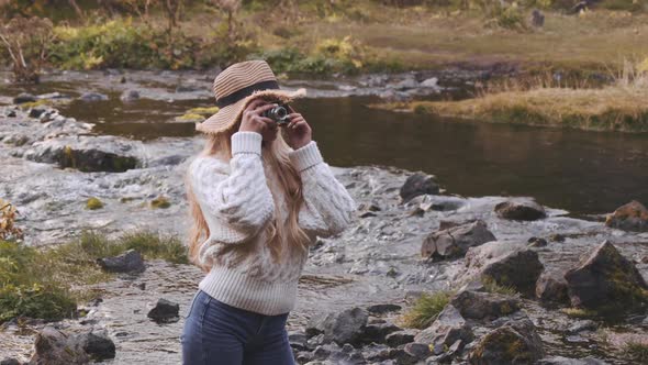 Woman Photographing From River With Vintage Camera