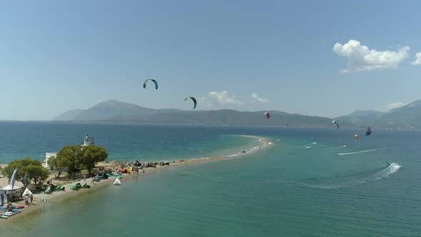 Aerial view of big group kitesurfing close to the shore.