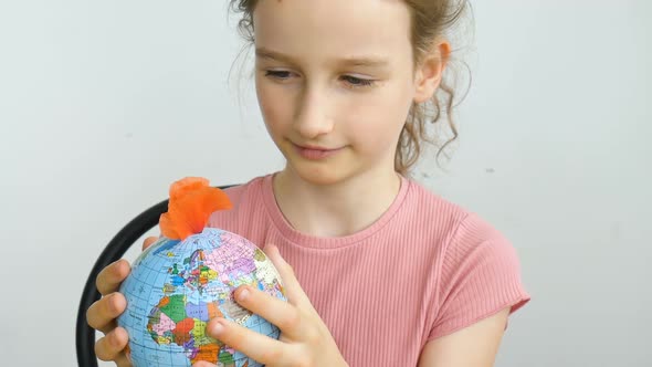 Earth Globe with Geographical Names in Ukrainian Cyrillic Letters with Flowers Growing From It is