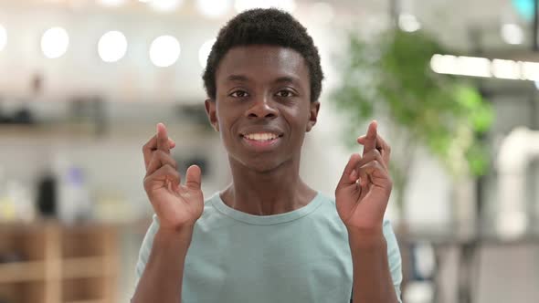 Finger Crossed Young African Man Praying for Good Luck