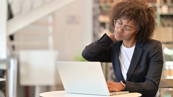 Tired African Businesswoman with Laptop Having Neck Pain at Cafe 