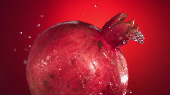 Super Slow Motion Water Drips on Rotating Pomegranate