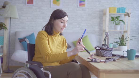 Portrait of a Young Disabled Woman in a Wheelchair Doing Makeup Going on a Date