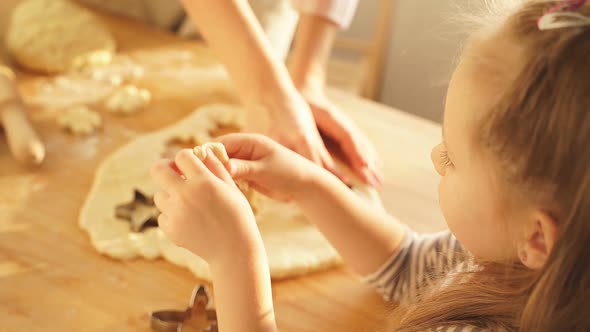 Little Girl and Her Mother Prepare Cookies for the Holiday