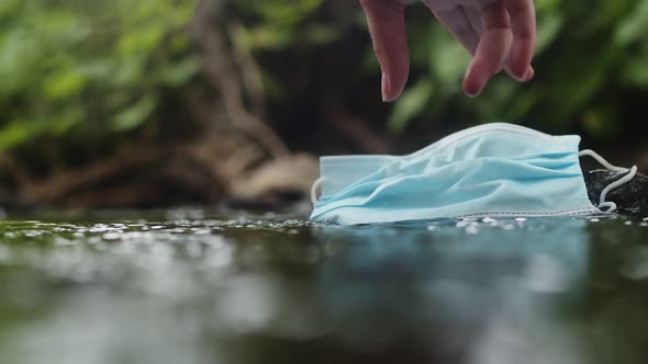 Hand of an Environmentalist Activist Raises a Used Medical Mask Polluting Nature the Concept of