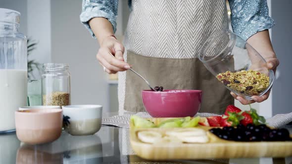 Lady Puts Oatmeal Flakes Into Bowl for Breakfast