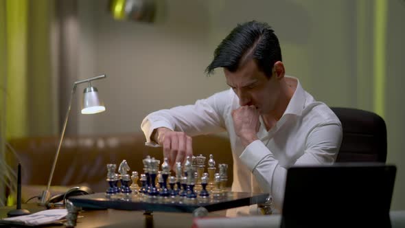 Concentrated Chess Player Sitting at Table at Home Practicing