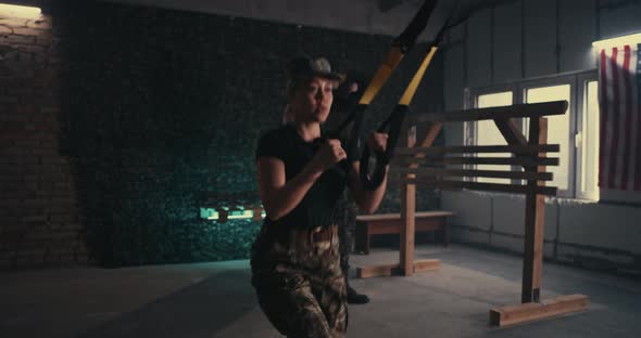 Female Soldier Doing TRX Lunge Near Squadmate