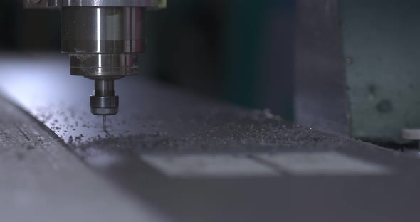 Milling Machine Cuts a Part From a Sheet of Metal Shavings Fly