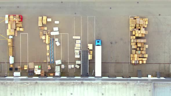 Aerial top down view of the big logistics park with warehouses, loading hub and a lot of semi trucks