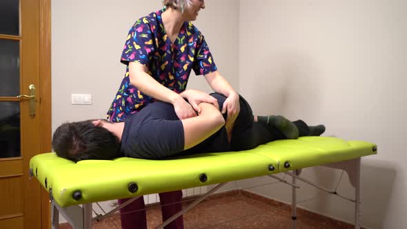 joint therapy with physiotherapist treating patient on green table