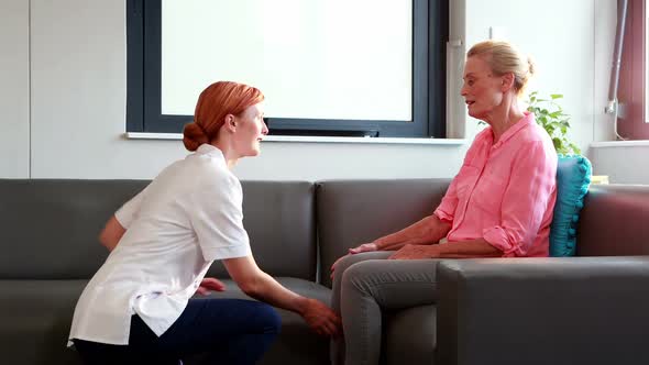 Nurse doing hand massage to her senior patient