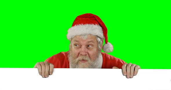 Surprised santa claus hiding behind green screen