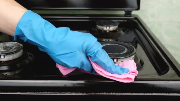 Wiping the Gas Stove with a Napkincleaning the Kitchen