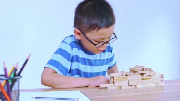 Asian boy playing with a wooden puzzle