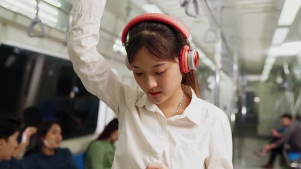 Young Woman Using Mobile Phone on Public Train