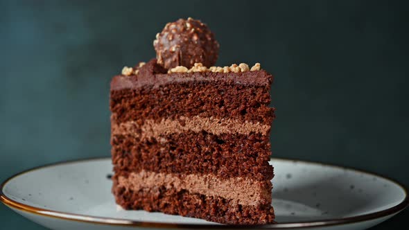 Piece of chocolate cake. Cake rotating. Chocolate dessert. Coffee cake on white plate.