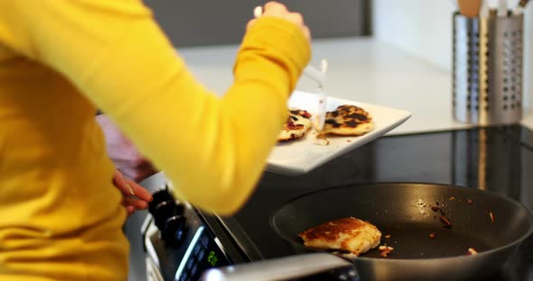 Woman preparing grapes tart and man using digital tablet in kitchen