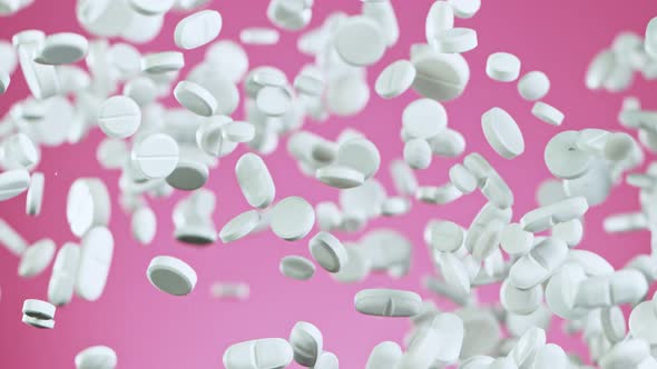 Super Slow Motion Shot of Flying White Pills on Pink Background at 1000Fps