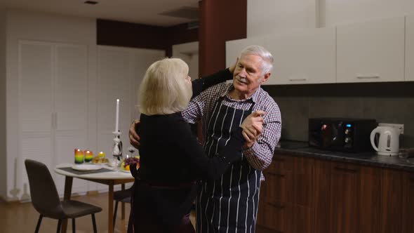 Senior Couple in Love Dancing. Romantic Evening Supper with Wine and Candles Celebrating Anniversary