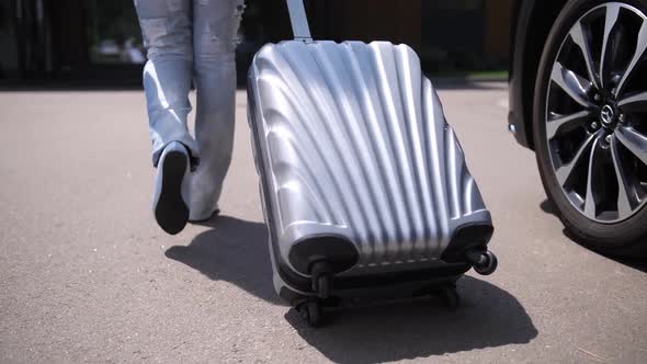 Legs of Woman Carrying Suitcase Walking From Car