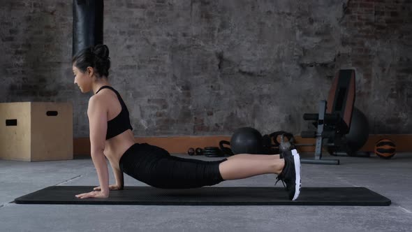 Flexible indian woman stretching in fitness club. Sporty woman training stretch exercise for press