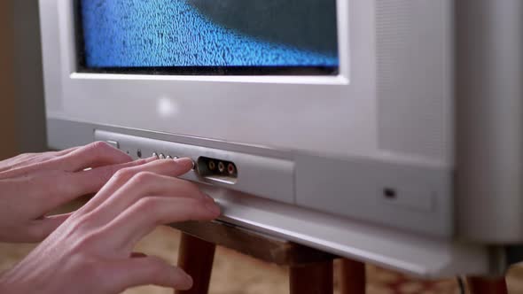 A Male Hand Presses the Buttons with Finger on Old Vintage TV with Interference