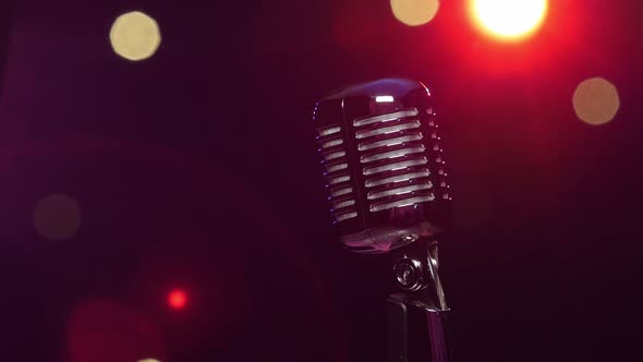 Classic Microphone Against Dark Blurry Background with Bright Flashing Lights