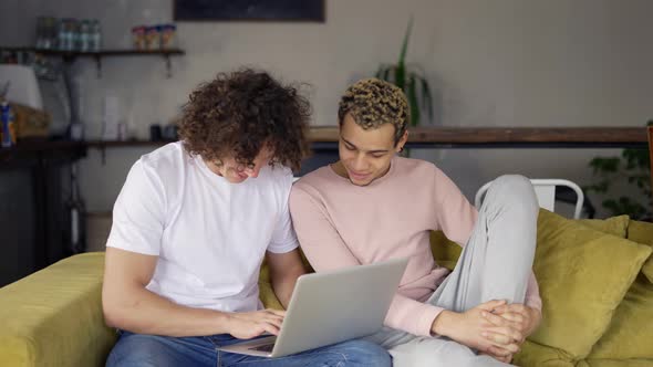 Two Male Gay Couple Using Laptop Computer for Video Calling or Surfing Internet