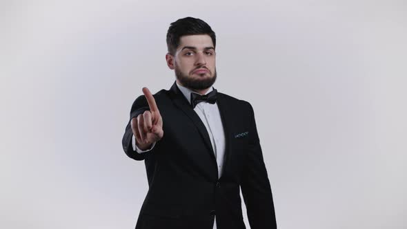 Portrait of Serious Man in Black Tuxedo Showing Rejecting Gesture By Stop Finger Sign