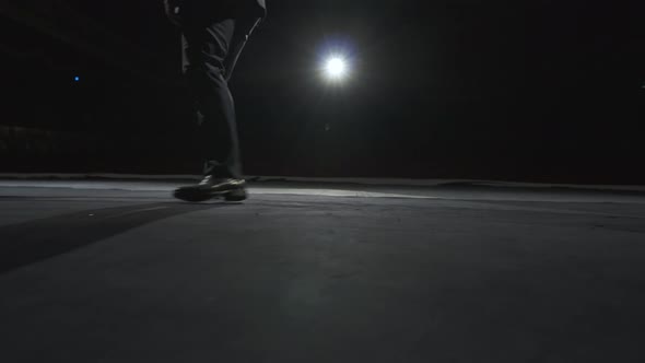 The legs of a dancer in shoes on a dark theater stage