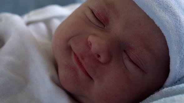 Closeup Newborn Baby Face Portrait Early Days in Macro Sleeping And Smiling Through Dream Background