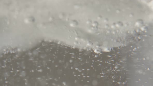 Ice cubes in sparkling water glass melting and cooling down and refreshing drink 4K 2160p 30fps Ultr