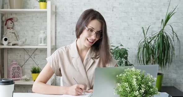 Young Beautiful Girl in Glasses Stay at Home and Working at Computer Thoughtful. Woman Works on