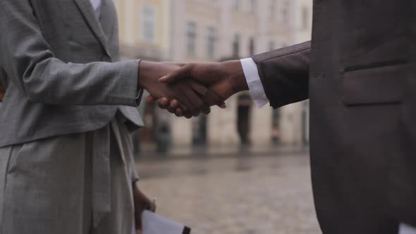 Close Up of Afro American Partners Shaking Hands Outdoors