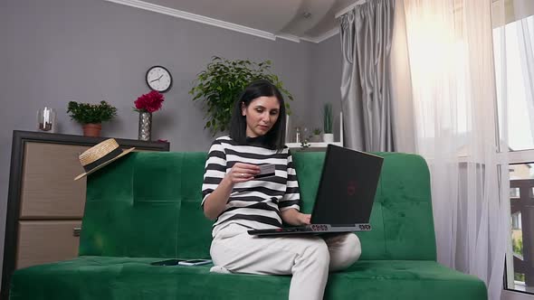 Woman at Home and Making Online Purchases Using Laptop and Personal Credit Card