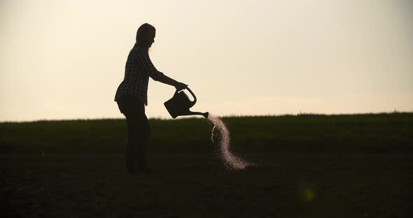 Female Farmer Watering Plants at Farm