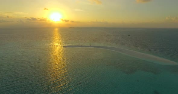 Aerial drone view of a man and woman eating dinner and dining on a tropical island beach