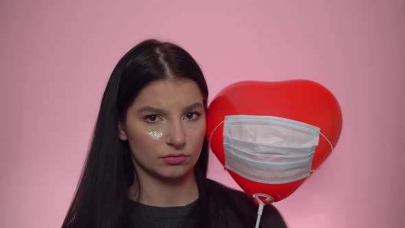 Sad Woman with Heart Ballon in Protective Mask